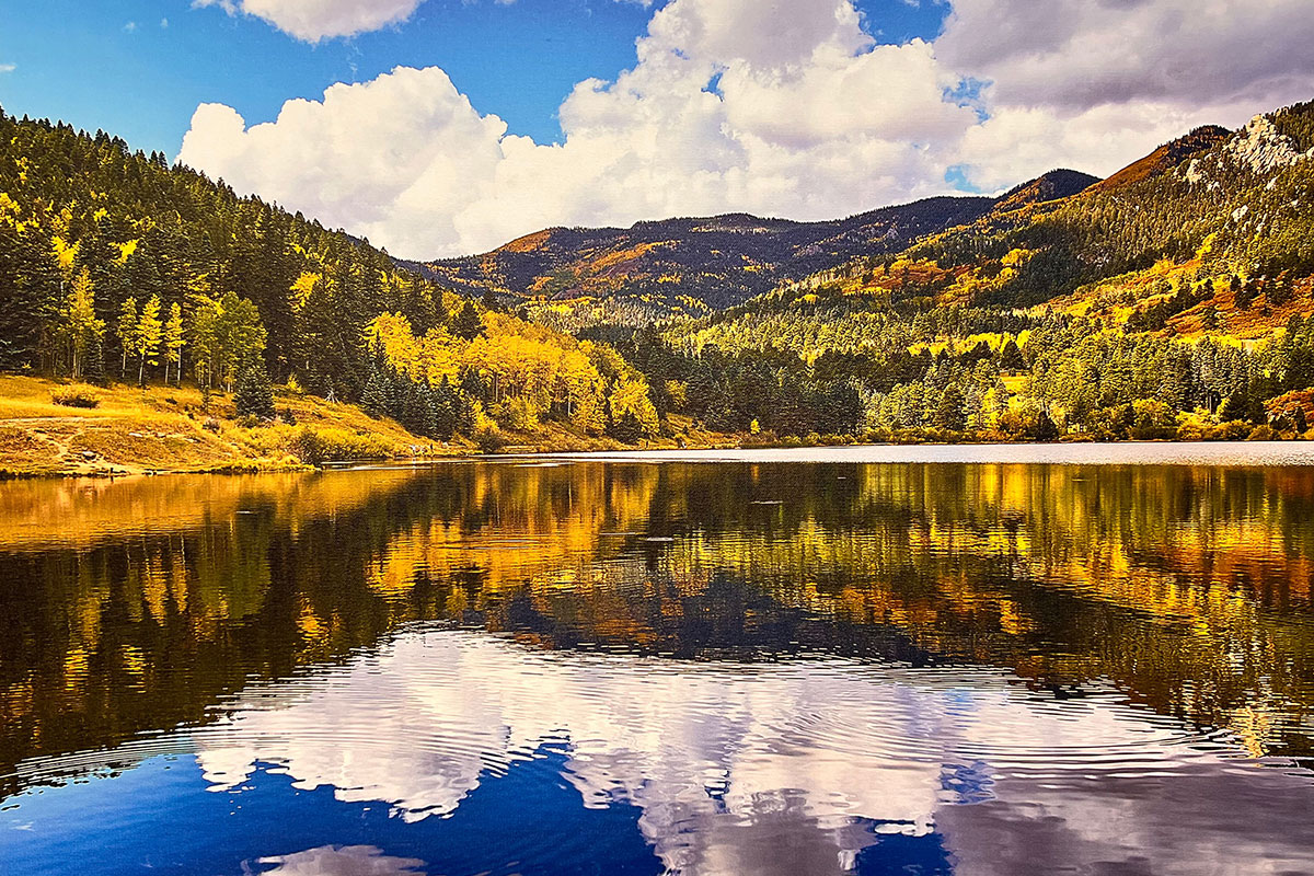 Photo of Colorado Mountains in the background with a reflecting lake in the foreground