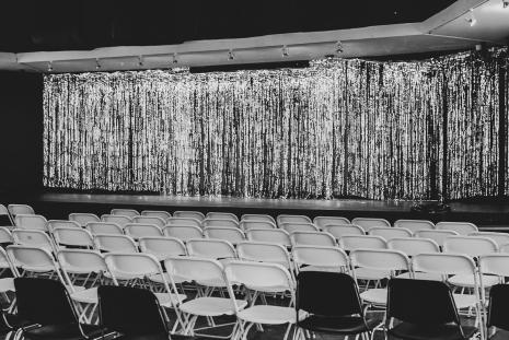 Stage with foil curtain and chairs at 2023 benefit